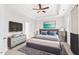 Well-lit main bedroom with a tray ceiling, ceiling fan, TV, and modern furnishings at 1400 Basley St, Wake Forest, NC 27587