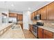 Gourmet kitchen featuring stainless steel appliances, granite countertops, and warm wood cabinetry at 1400 Basley St, Wake Forest, NC 27587