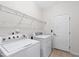 A functional laundry room with a washer, dryer, wire shelving, and a door, offering convenience at 1400 Basley St, Wake Forest, NC 27587