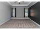 Bright bedroom featuring two windows, ceiling fan, and a dark accent wall at 16 Sourgum Ct Ct, Zebulon, NC 27597