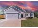 White farmhouse exterior with gray roof, two-car garage, and manicured lawn at 16 Sourgum Ct Ct, Zebulon, NC 27597