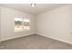 Cozy bedroom featuring neutral carpet, a large window with wooded views, and fresh white paint at 1701 Drayton Hall Ln, Sanford, NC 27330