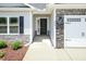 Front entrance showing the door, stone facade, flower bed, and garage at 1701 Drayton Hall Ln, Sanford, NC 27330