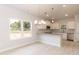 Bright kitchen featuring white cabinetry, granite counters, stainless appliances, and a lovely light fixture at 1701 Drayton Hall Ln, Sanford, NC 27330