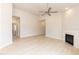 Open-concept living room with a fireplace, ceiling fan, and light hardwood floors at 1701 Drayton Hall Ln, Sanford, NC 27330