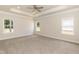 Large main bedroom with tray ceiling, ceiling fan, carpet, and multiple windows at 1701 Drayton Hall Ln, Sanford, NC 27330