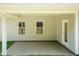 Covered back patio with a concrete floor and two windows at 1701 Drayton Hall Ln, Sanford, NC 27330