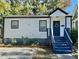 Charming white house with blue steps, landscaping, and gravel driveway at 1712 Rosetta Dr, Durham, NC 27701