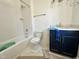 A full bathroom with a white tiled shower, white toilet, and blue vanity with quartz countertop at 1725 Burnette Garden Path, Raleigh, NC 27612