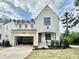 Striking two-story white brick home with a finished front yard and an attached two-car garage at 1725 Burnette Garden Path, Raleigh, NC 27612