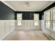 Inviting room featuring black accent walls, white wainscoting, and natural light from three windows at 1725 Burnette Garden Path, Raleigh, NC 27612