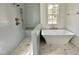 Modern bathroom with a freestanding tub, tiled shower, and marble floors at 1725 Burnette Garden Path, Raleigh, NC 27612