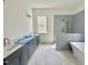 Modern bathroom with a double vanity, marble floors, a freestanding tub, and a glass-enclosed shower at 1725 Burnette Garden Path, Raleigh, NC 27612