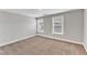 Well-lit bedroom with neutral carpeting and two windows at 201 Brickwell Way, Youngsville, NC 27596