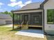 Back porch with wooden stairs leading to a concrete patio and a lush yard at 320 Pilot Ridge Rd, Zebulon, NC 27597