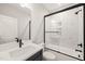 Bathroom features a sleek vanity and a shower-tub combination enclosed with clear glass and black trim at 320 Pilot Ridge Rd, Zebulon, NC 27597
