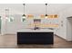 Bright kitchen boasts a center island, modern lighting, and custom cabinetry with hidden storage at 320 Pilot Ridge Rd, Zebulon, NC 27597