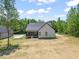 Rear view of the house with a spacious yard and a screened in porch at 320 Pilot Ridge Rd, Zebulon, NC 27597