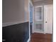 Hallway featuring dark wood floors, white trim, and a built-in shelving unit with glass shelves at 420 Parkview Dr, Burlington, NC 27215