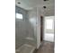 Modern bathroom featuring white tile, a built-in shower seat, and an adjacent hallway for convenience at 53 Priming Way, Angier, NC 27501