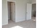 Bright bedroom featuring neutral walls, carpet, and an open closet with a white door at 53 Priming Way, Angier, NC 27501
