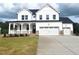 Charming two-story home featuring a welcoming front porch and a spacious three-car garage at 53 Priming Way, Angier, NC 27501