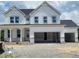 A modern two-story home with white siding, a dark roof, and an attached two-car garage at 53 Priming Way, Angier, NC 27501