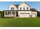 Charming two-story home featuring a welcoming front porch and an attached two-car garage at 53 Priming Way, Angier, NC 27501