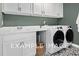 Laundry room with white cabinets, washer, dryer, and patterned floor at 53 Priming Way, Angier, NC 27501