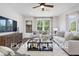 Comfortable living room with light-colored sofa and large windows at 53 Priming Way, Angier, NC 27501