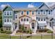 Three-story townhouses with varying exterior colors and a brick base at 705 Traditions Grande Blvd, Wake Forest, NC 27587
