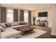 Living room with staged furniture, hardwood floors, and large windows at 705 Traditions Grande Blvd, Wake Forest, NC 27587