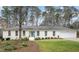 Ranch style home with a white brick facade, attached garage, and manicured lawn at 908 Glen Eden Dr, Raleigh, NC 27612