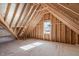 Unfinished attic space with window and wood framing at 100 Sire Ct, Holly Springs, NC 27540