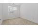 Minimalist bedroom with neutral carpet and a bright window for natural light, simple and clean design at 10310 Sablewood Dr # 108, Raleigh, NC 27617