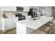 White kitchen island with quartz countertops and stainless steel sink at 104 Cavalier Rider Run, Wendell, NC 27591