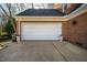 White double garage door with brick facade and potted plants at 1302 Apache Ln, Apex, NC 27502