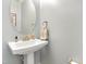 Small bathroom with pedestal sink and oval mirror at 139 Red Angus Dr, Smithfield, NC 27577