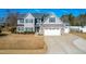 Two-story house with gray siding, stone accents, and a three-car garage at 139 Red Angus Dr, Smithfield, NC 27577