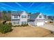 Two-story house with gray siding, stone accents, and a three-car garage at 139 Red Angus Dr, Smithfield, NC 27577