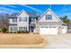 Two-story house with gray siding, stone accents, and a three-car garage at 139 Red Angus Dr, Smithfield, NC 27577