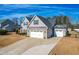 Two-story house with gray siding, stone accents, and a three-car garage at 139 Red Angus Dr, Smithfield, NC 27577