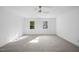 Bright bedroom with neutral carpeting, ceiling fan, and large windows at 1800 Deer Fern Dr, Raleigh, NC 27606