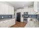 Modern kitchen with white cabinets, granite countertops, and stainless steel appliances at 187 Ashley Woods Ct, Clayton, NC 27527