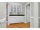 Bright butler's pantry features white cabinets with glass doors and granite countertop at 2008 Joelene Dr, Rocky Mount, NC 27803