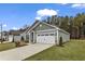 Gray exterior house with white garage door and landscaping at 207 Brickwell Way, Youngsville, NC 27596