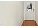 Hallway with white walls, hardwood floor, and a white door with glass insert at 219 Broadgait Brae Rd, Cary, NC 27519