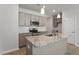Well-lit kitchen featuring gray cabinets, stainless appliances, and a granite island at 284 Chesapeake Commons St # 150, Garner, NC 27529