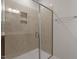 Glass enclosed shower stall with tiled walls and recessed shelving at 288 Chesapeake Commons St # 149, Garner, NC 27529