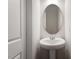 Neutral-toned powder room with pedestal sink and oval mirror at 288 Chesapeake Commons St # 149, Garner, NC 27529